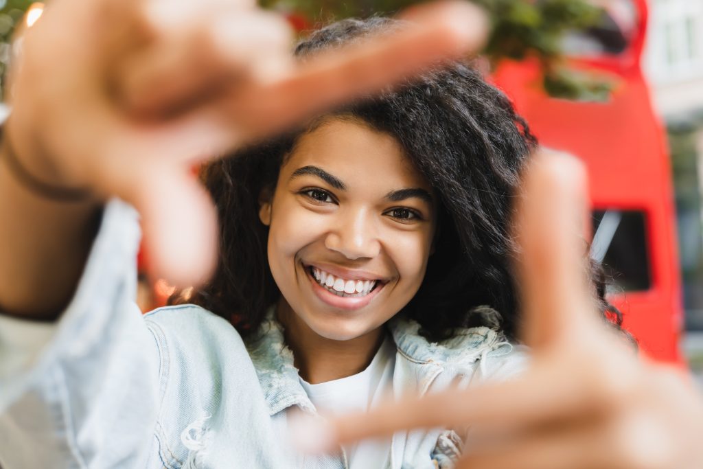 Smiling african-american woman young student freelancer taking selfie photo on smart phone